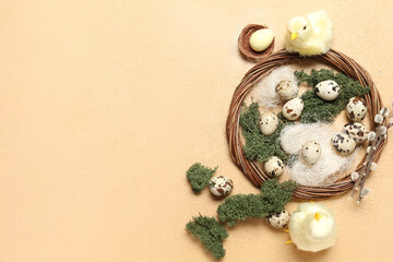 Composition with Easter quail eggs, baby chickens and wreath on beige background