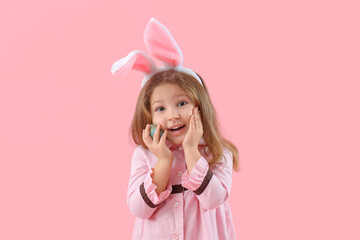 Obraz na płótnie Canvas Cute little girl in bunny ears with Easter egg on pink background