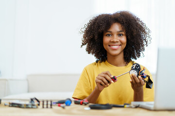 Happy cheerful American - African black ethnicity female university student learning about robotic...