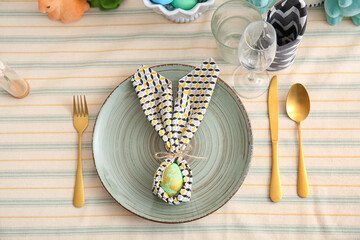 Table serving with Easter egg wrapped in bunny ears napkin and cutlery