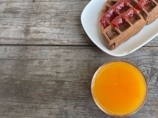 Breakfast of waffle chocolate with strawberry jam and orange juice