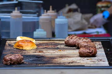 Picture of a bunch of hamburgers,, ready to get grilled served and be eaten in a fast-food restaurant, on a grill.