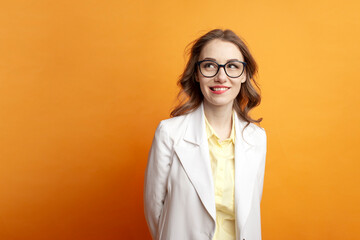 excited business woman in glasses and suit biting her lip and dreaming on color background, pensive girl manager