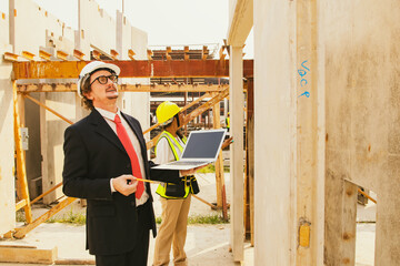 Architect caucasian housing estate inspect prefab house wall in factory warehouse with female worker walking inspect finished molding for quality alternatives, validated strong structure standards.
