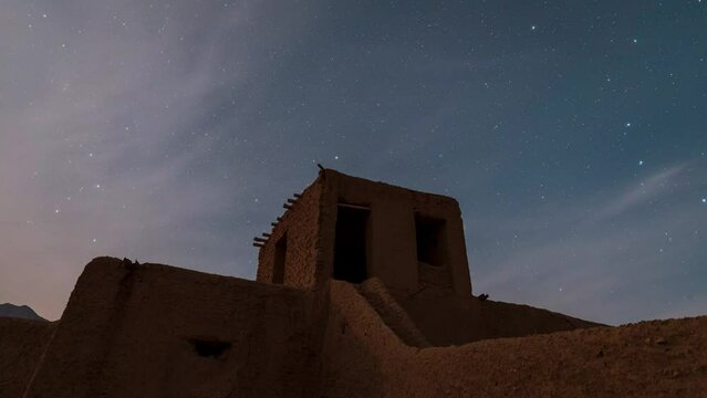Moon light reflection on clay mud brick adobe handmade wall of a traditional local nomad native people in rural night area district in central desert in Iran abandoned settlement house star in the sky