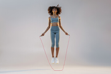 Woman skipping with jump rope on studio background. Strength and motivation. Best cardio workout