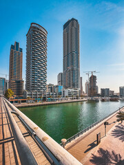 Naklejka premium Dubai Marina, harbour, cruise boat and canal promenade view at sunset, in Dubai, United Arab Emirates