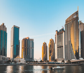 Fototapeta na wymiar Dubai Marina Mosque, harbour, cruise boat and canal promenade view at sunset, in Dubai, United Arab Emirates