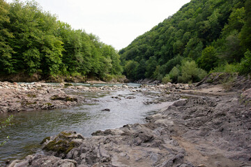 Summer, river, mountainous terrain, tourist routes running through the park, a place for walking and recreation.