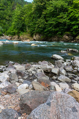 Summer, river, mountainous terrain, tourist routes running through the park, a place for walking and recreation.