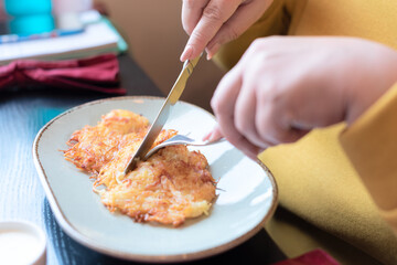 Plus size body positive woman dressed in yellow having breakfast at the cafe early in the morning with selective focus