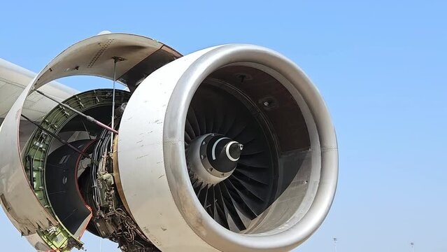 Jet turbine engine of aircraft rotating by wind with blue sky background.Aviation industry  aircraft open engine cover for maintenance.