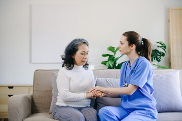 Obraz premium Medical doctor holing senior patient's hands and comforting her at home