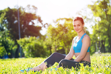 Beautiful smiling girl in sportswear relax in park