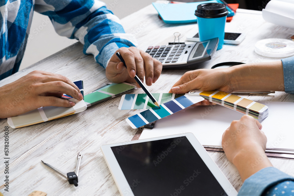 Wall mural Designers discussing color palette at desk