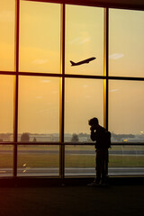 Fototapeta na wymiar Silhouette of a man at the airport with an airplane in the background