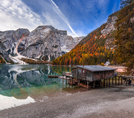 Lake Braies, Italy - Beautiful autumn morning at Lake Braies (Lago di Braies) in the Italian Dolomites at South Tyrol with wooden boats, wooden cabin blue sky and reflecting Seekofel Mountain