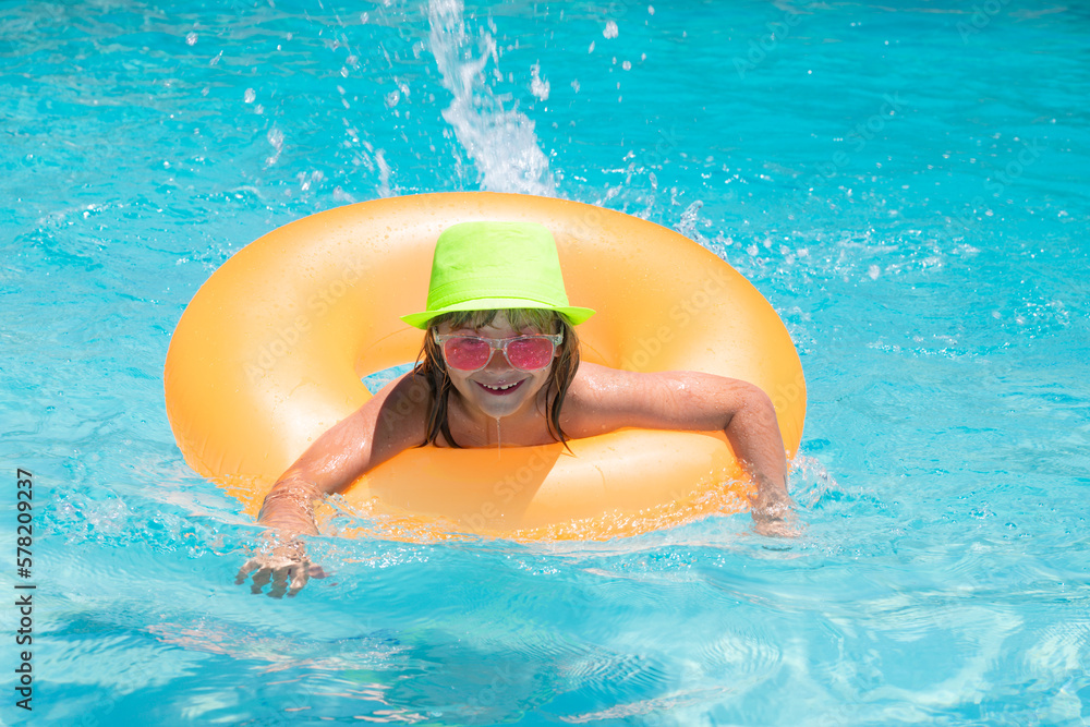 Wall mural Summer relax. Child splashing in swimming pool. Swim water sport activity on summer vacation with child. Child water toys, floating ring.