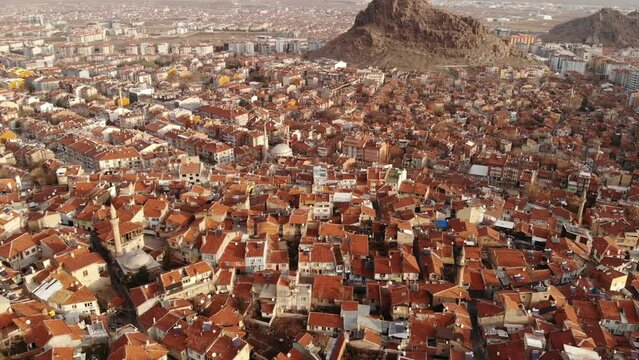 Aerial view of Afyonkarahisar cityscape with similar brownish tiled roofs on residential buildings on sunny winter day, Turkey. High quality 4k footage