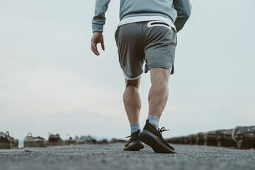 healthy lifestyle young fitness man running at seaside old bridge. Outdoor workout,  Healthy lifestyle concept.