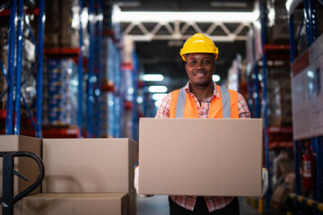 African American male warehouse worker hold cardboard box packaging in warehouse distribution...