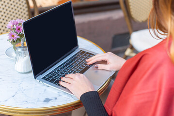 young woman businesswoman sits in a cafe behind a laptop. Business, work online