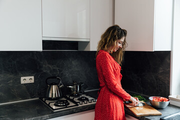 a woman in the kitchen prepares food salad healthy food near the sink