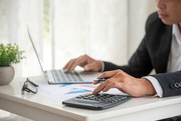 Asian businessman hands calculating number, graph, chart audit planning accountancy on business...