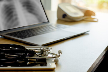 Doctor's office desk with medical stethoscope, laptop computer, digital tablet, electronic pen and...