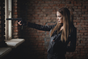 Beautiful girl a secret agent with silenced pistol concept.