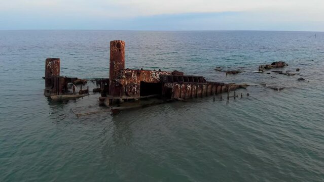 Drone Video passing over shipwreck Blue sea waters top down view