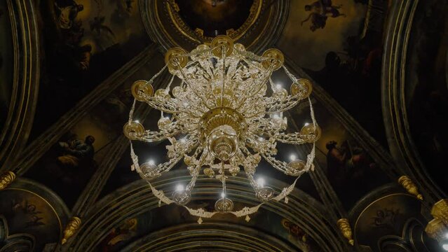 Tracking shot of a golden big chandelier inside a big cathedral