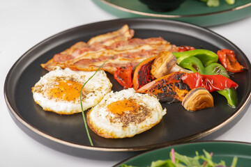 Healthy Breakfast of Fried eggs with bacon and grilled veggies 