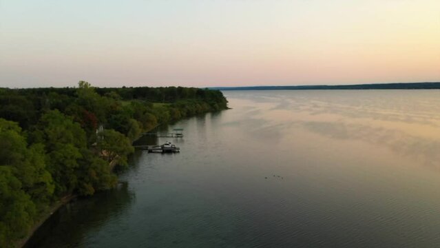 Beautilful drone aerial fly over of the shores and boat docks or Seneca Lake New York at sunset