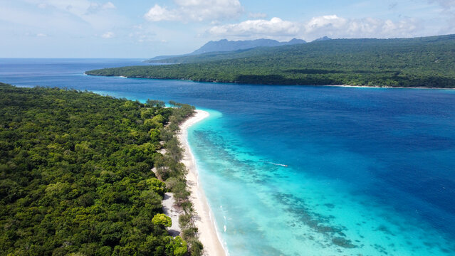 Aerial view of remote, uninhabited Jaco Island and mainland Timor Leste, Southeast Asia, tropical island destination with white sandy beaches and stunning turquoise ocean views