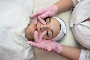 Fototapeta na wymiar Young woman receive face massage at spa salon