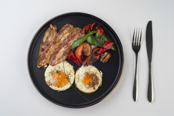 Healthy Breakfast of Fried eggs with bacon and grilled veggies 