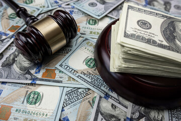 Judge's hammer lying on 100 new dollar money