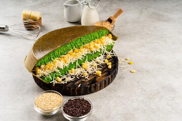 Martabak manis or terang bulan is indonesian sweet pancake, with green color and filled with...