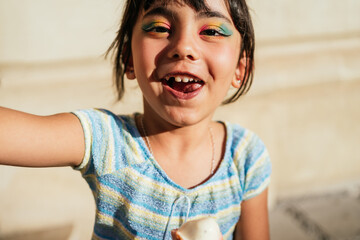 Child smiling looking at the camera with an ice cream in her hands.