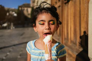 Little girl eating a melting ice cream in the street