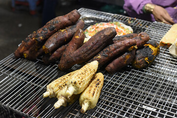 Grilled corn near vietnamese pancake with eggs, sausages and sauces in vietnamese night market in Da Lat