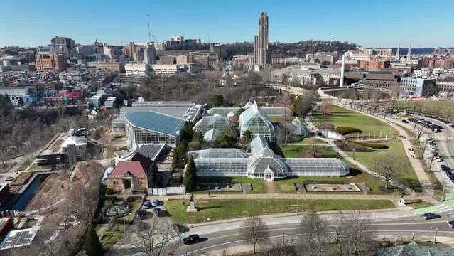 Phipps Botanical Garden in Schenley Park in Pittsburgh, Pennsylvania. Aerial pull back reveal reverse shot of public garden and University of Pittsburgh Cathedral of Learning.