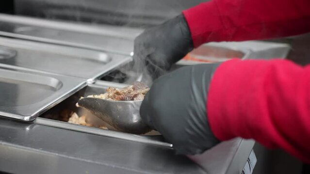 Measuring out marinated, chopped chicken and pork for a taco, burrito, mulita, or quesadilla - food truck series