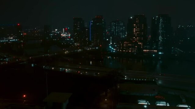 Wide shot of residential New York City, highway, river, cars, traffic, night