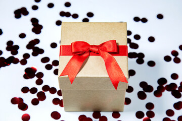 Gift box with red ribbon on white background with dark red spotes