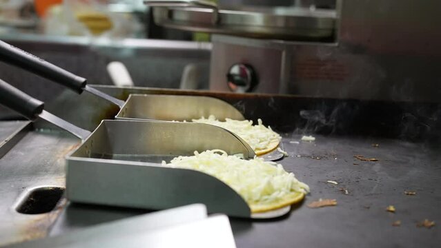 Melting cheese on tortilla shells to make mulitas - food truck series