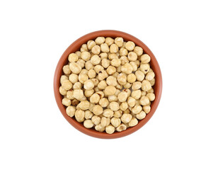Peeled hazelnuts in a terracotta bowl on white background.