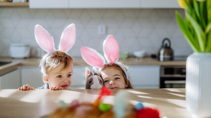 Little siblings enjoying easter time together in home.