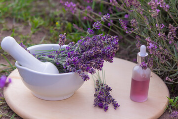 Obraz na płótnie Canvas jars with lavender oil, lavender flowers, on the background of a lavender field.